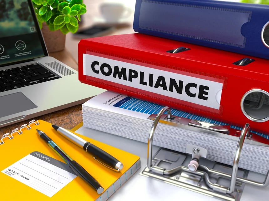 Red-Ring-Binder-with-Inscription-Compliance-on-Background-of-Working-Table-with-Office-Supplies-Laptop-Reports.-Toned-Illustration.-Business-Concept-on-Blurred-Background.